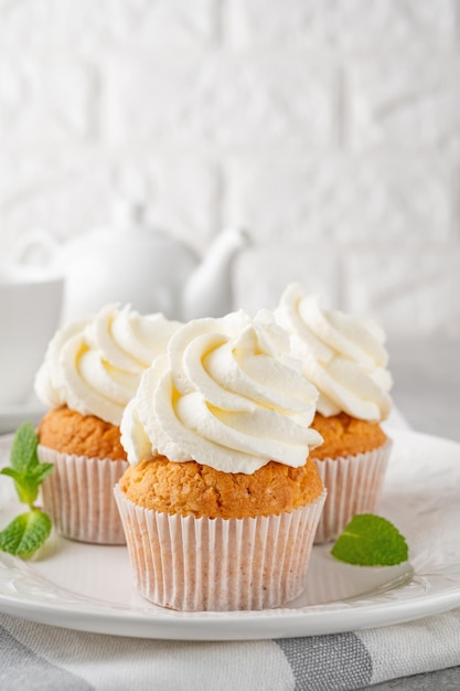 Delicious vanilla cupcakes with cream cheese and sugar candy Dessert for birthday selective focus