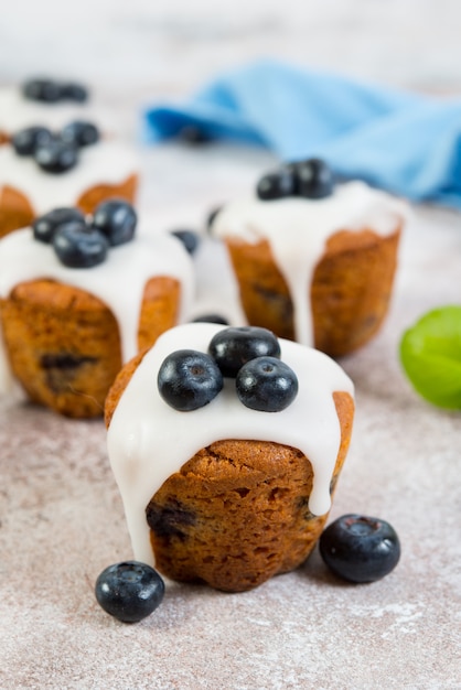 Delicious vanilla muffins in sugar Fudge lie on a concrete wall. Vertical  photo.