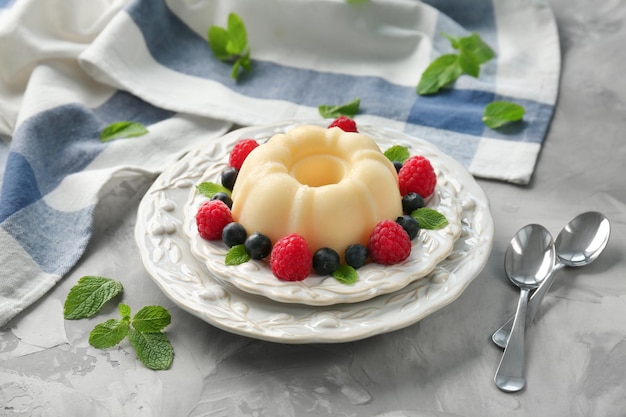 Delicious vanilla pudding with berries on table