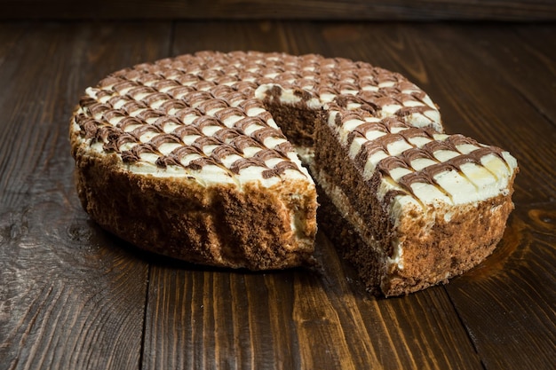 Вкусный веганский шоколадный торт со сливками на темном деревянном фоне крупным планом