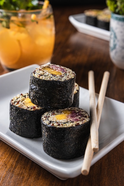 Delicious vegan sushi roll with wooden chopsticks