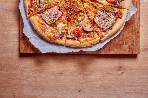 Foto deliziosa pizza vegetariana con cipolla ai funghi peperone verde e salsa di pomodoro tavolo in legno