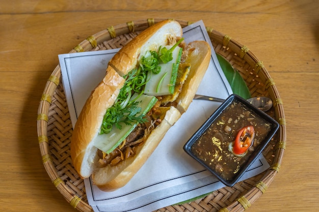 Foto delizioso pollo vietnamita banh mi servito su un tradizionale vassoio di rattan