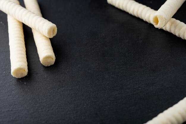 Delicious wafer rolls isolated on black background