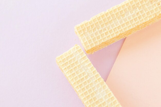 Delicious wafer sticks on pastel background