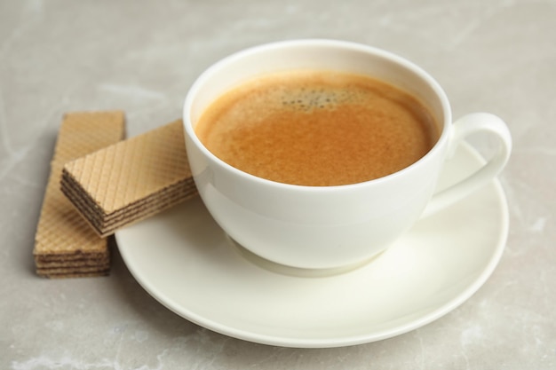 Delicious wafers and cup of coffee for breakfast on grey marble table