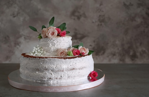 Delicious wedding cake on table and grey textured background