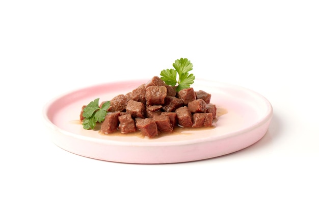 Delicious wet food for a cat or dog pieces of nutritious meat for an animal dog or cat in a plate on a white background