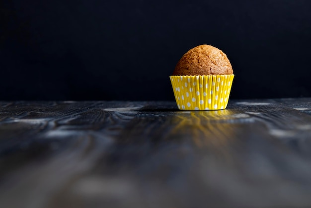Delicious wheat cupcakes on a black wooden table