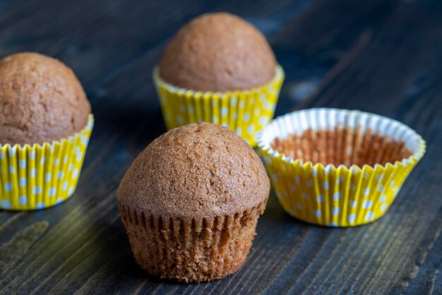 Delicious wheat cupcakes on a black wooden table