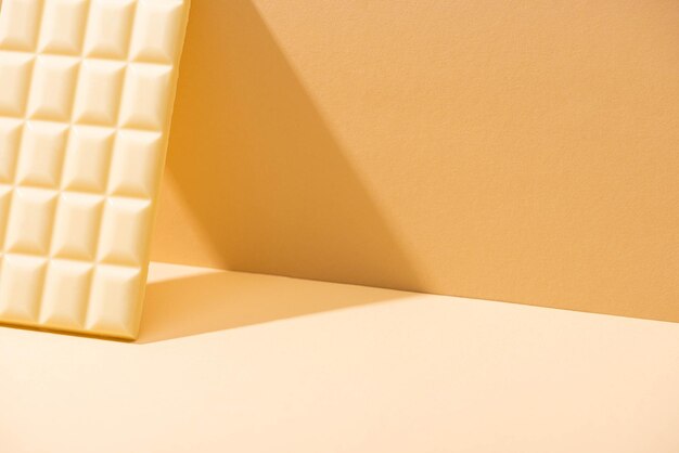 Delicious white chocolate bar on beige background