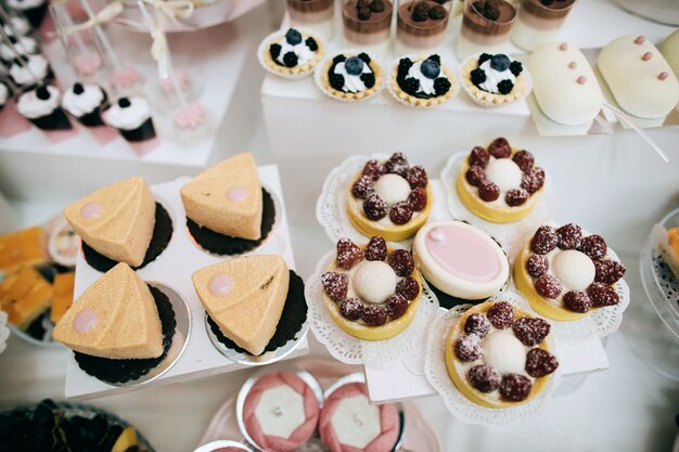 Delicious white wedding reception candy bar dessert table	