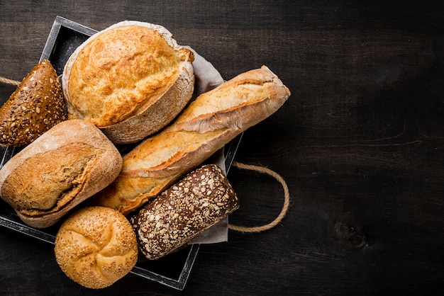 Foto delizioso pane bianco e integrale in cestino di legno