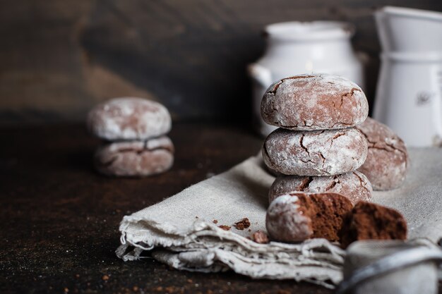 Deliciouse biscotti al cioccolato fatti in casa con zucchero a velo sul tavolo di pietra scura