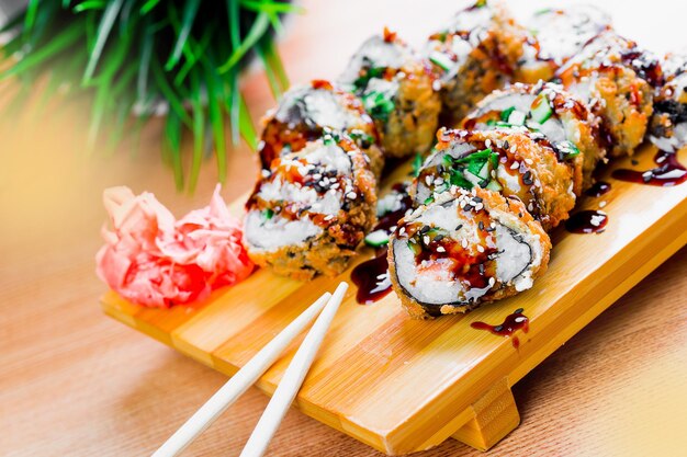 맛있게 준비 된 수시 롤 은 식당 에서 나무판 에 우아 하게 여 있고,  에 매운 생강 이 있다