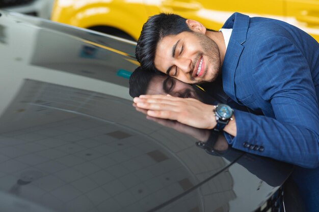 Delighted arab businessman hugging car of his dream