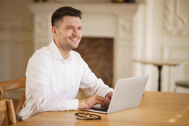 Photo a delighted businessman engages with a laptop his jovial demeanor indicative of a successful