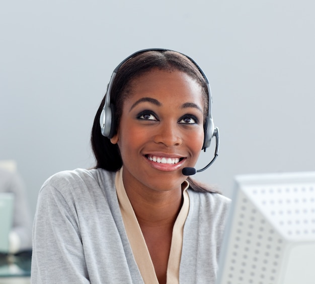 Delighted businesswoman using headset at her desk