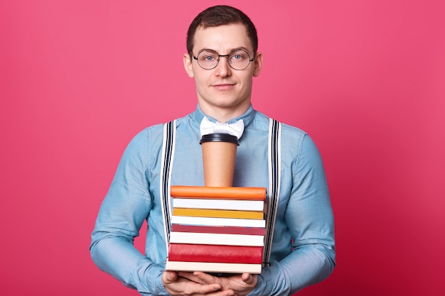 Delighted determined student poses isolated over pink