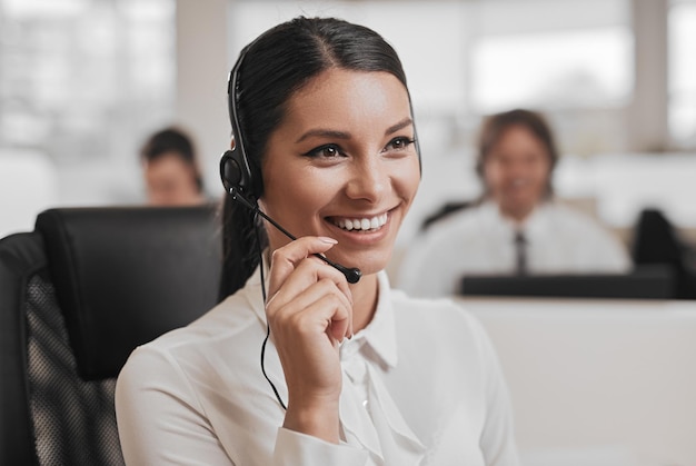 Delighted ethnic female customer support agent having call in modern office