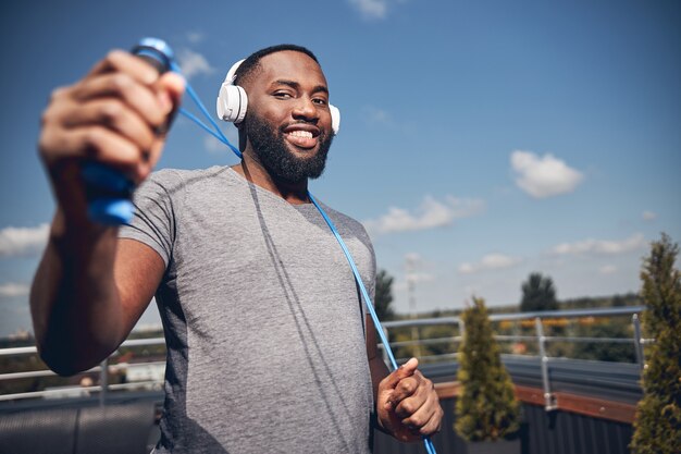 Delighted international male person holding sport equipment