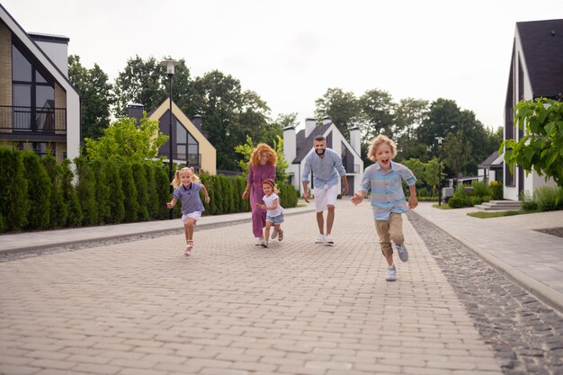 Felice famiglia gioiosa che corre per strada