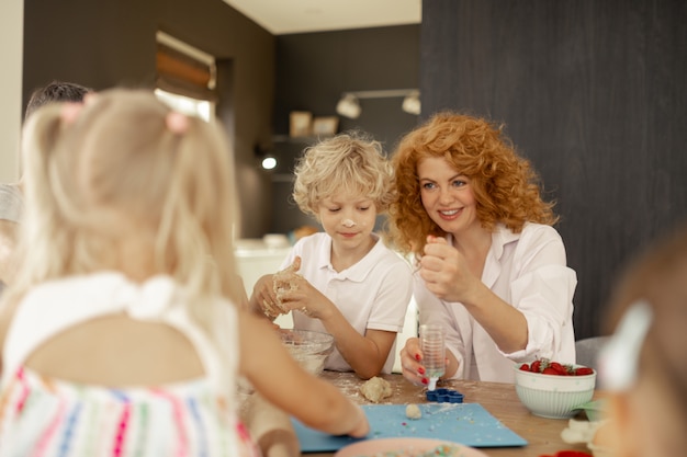 Delighted red haired woman looking at her daughter