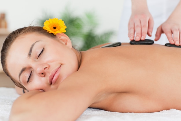 Delighted woman having a hot stone massage 