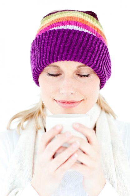 Delighted woman with a colorful hat and a cup in her hands