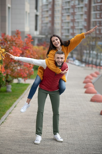 Delighted young couple being in a great mood while enjoying their time outdoors