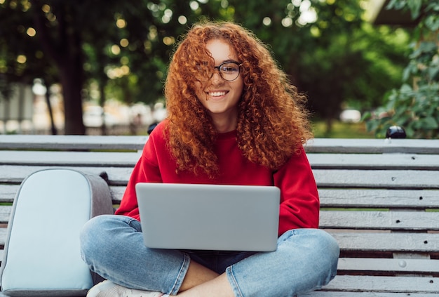 Delighted young female using laptop for studies