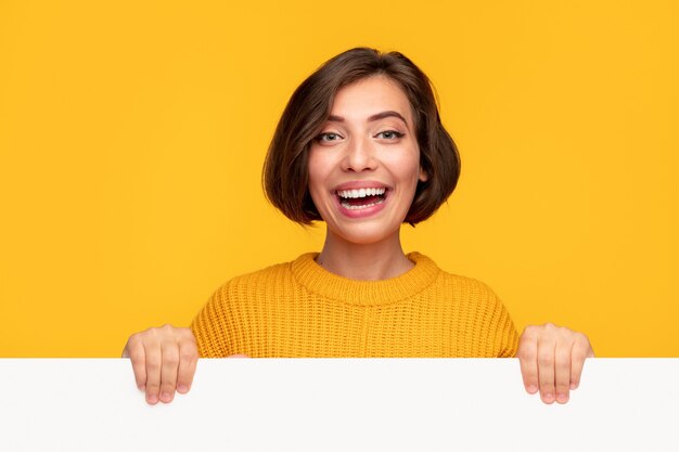 Delighted young female with blank banner