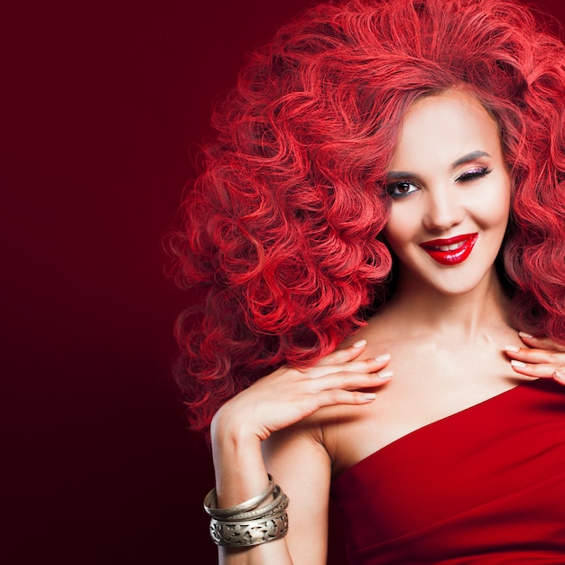 Delightful red-haired woman winks. Young woman in total red style