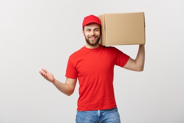 Deliver Concept: Young caucasian handsome delivery man holding a box on shoulder.