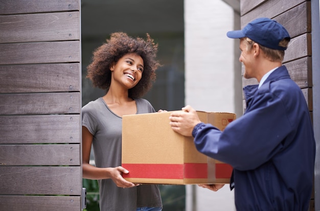 Delivering direct to your door. Shot of a courier making a delivery to a smiling customer.