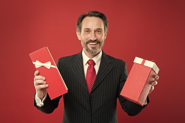 Delivering gifts to you Mature man smile with wrapped gifts Happy businessman hold gifts in hands Senior person with birthday gifts Anniversary or jubilee Birthday holiday Formal celebration