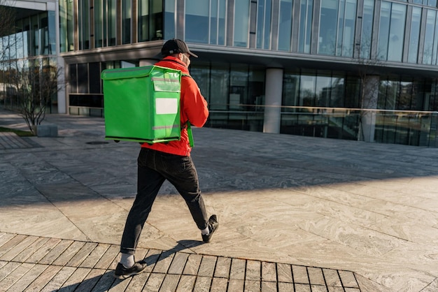 Delivers lunch to order from the restaurant in a thermos bag A young man walking to the office