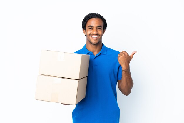 Delivery African American man with braids isolated on white pointing to the side to present a product