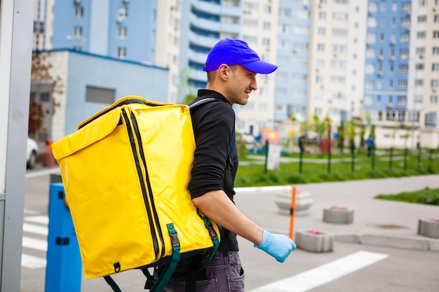 delivery boy of food delivery service walking down the street