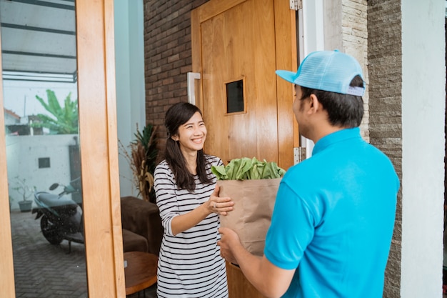 Delivery boy is delivering some groceries to woman