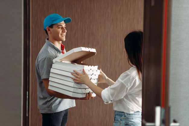 Delivery boy shows pizza to female customer