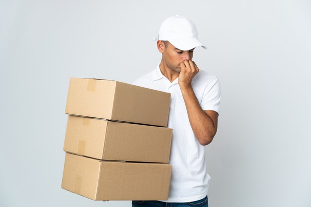 Delivery Brazilian man isolated on white wall having doubts