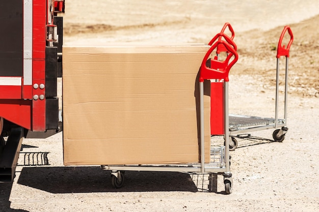 Photo delivery carrying cardboard box in hand truck trolley from van post service