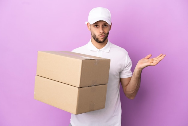 Delivery caucasian man isolated on purple background having doubts while raising hands