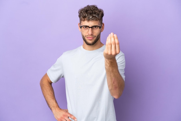 Delivery caucasian man isolated on purple background making Italian gesture