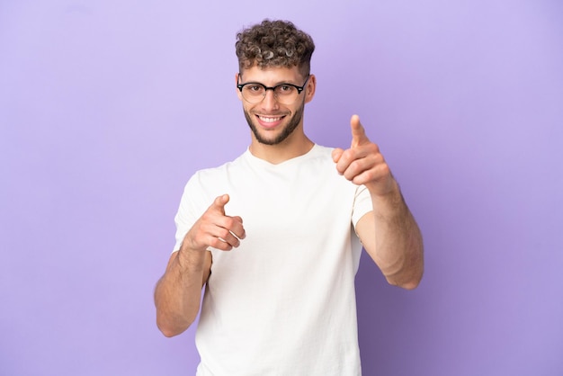 Delivery caucasian man isolated on purple background pointing front with happy expression