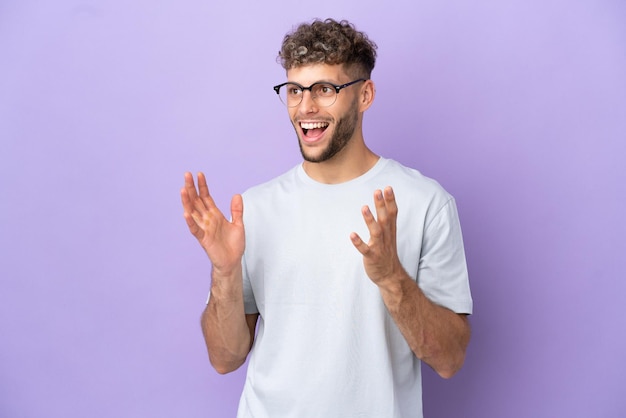 Delivery caucasian man isolated on purple background with surprise facial expression