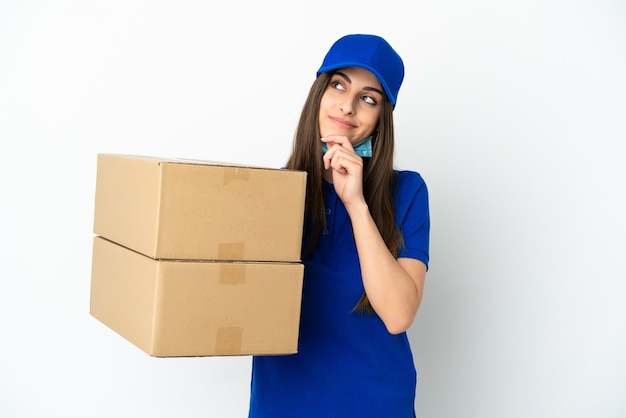 Delivery caucasian woman isolated on white background and looking up