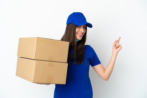 Delivery caucasian woman isolated on white background pointing back