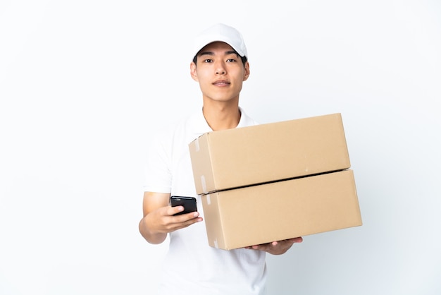 Delivery Chinese man isolated on white space sending a message with the mobile